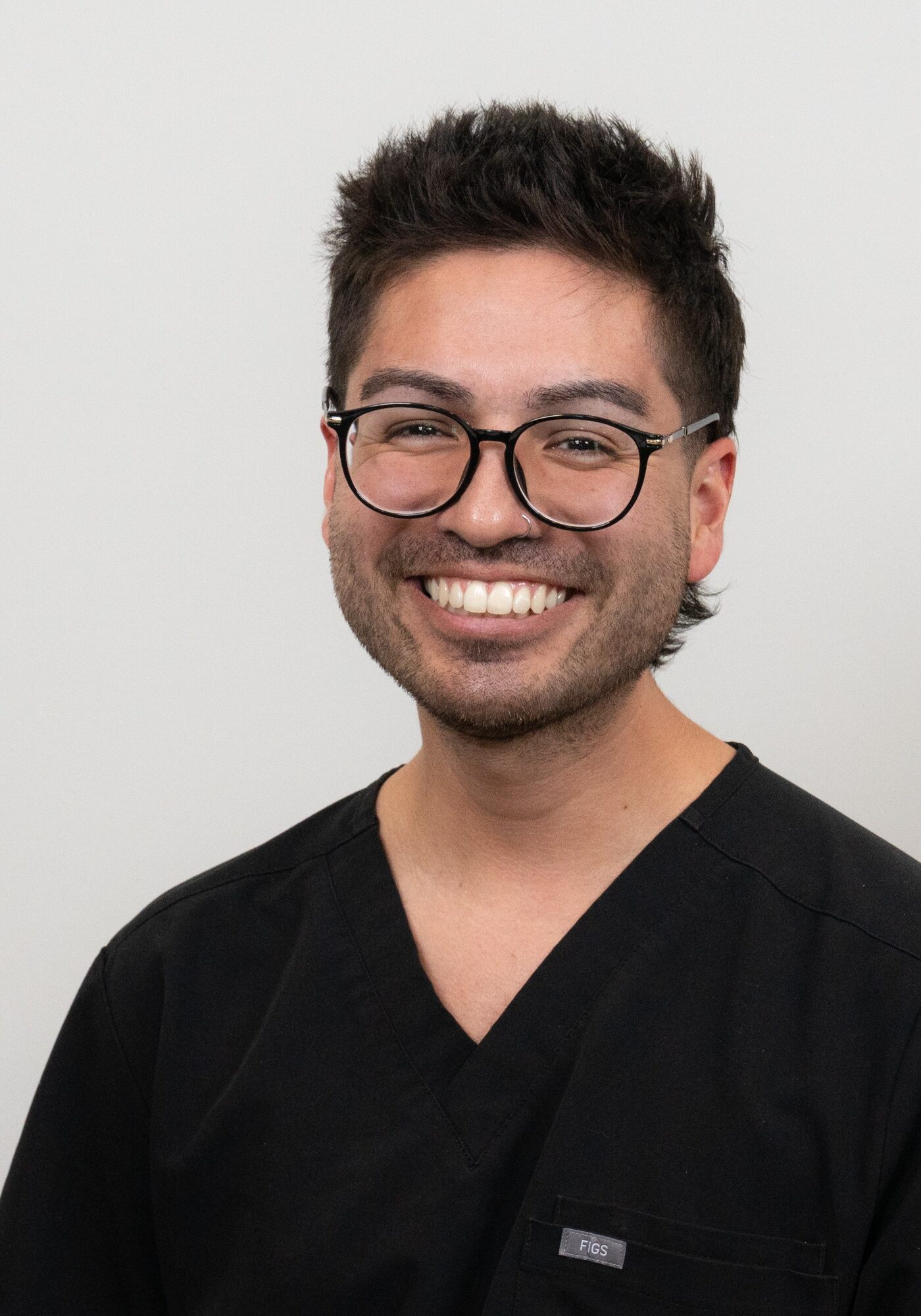 Orthodontic Tech Ben smiling in black scrubs, showcasing expertise and friendliness at Hoagburg Orthodontics.