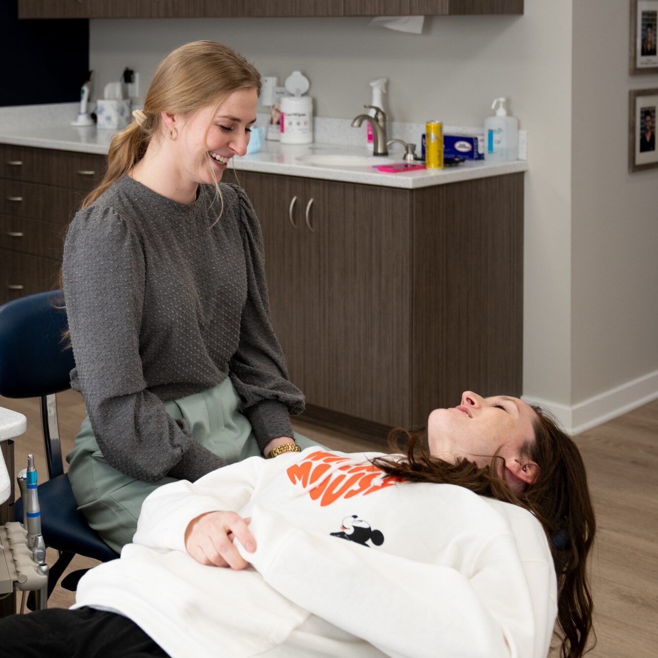 Patient consultation at Hoagburg Orthodontics, with a smiling staff member assisting a relaxed patient in a modern orthodontic office setting.