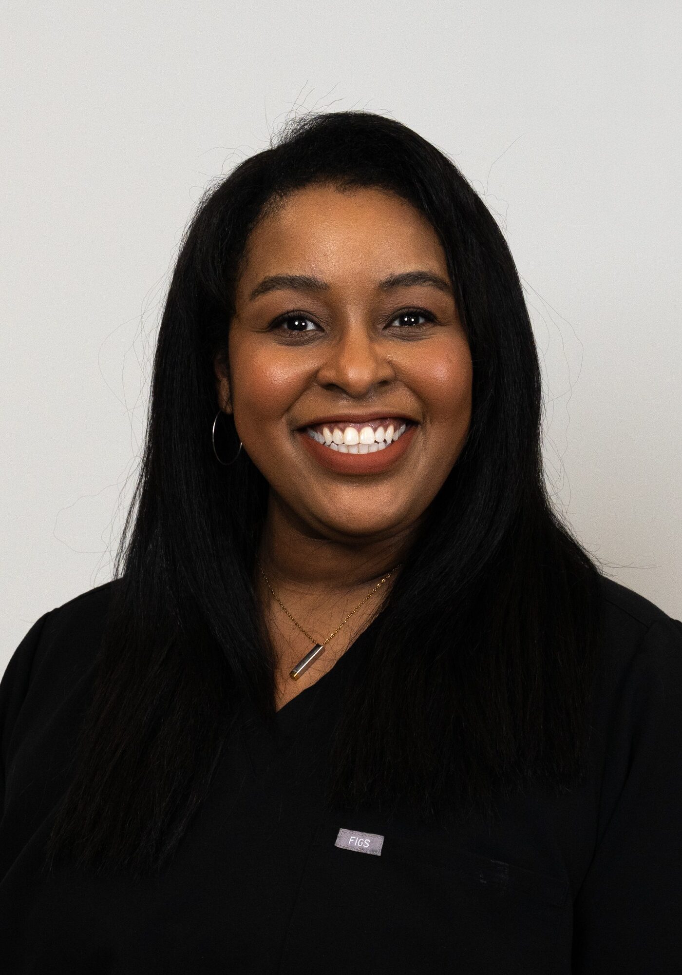 Smiling woman in black scrubs representing Hoagburg Orthodontics as a Lab Tech, showcasing the friendly team dedicated to exceptional orthodontic care.